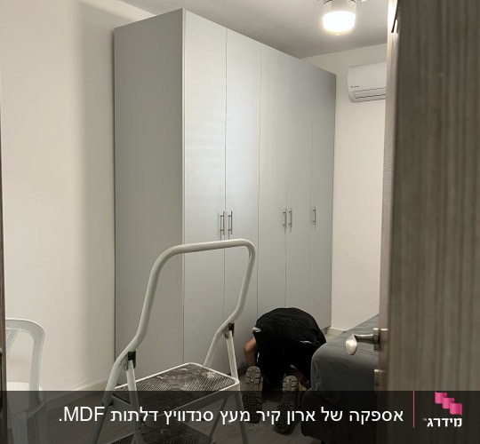 נגר עובד על ארון בגדים בחדר שינה